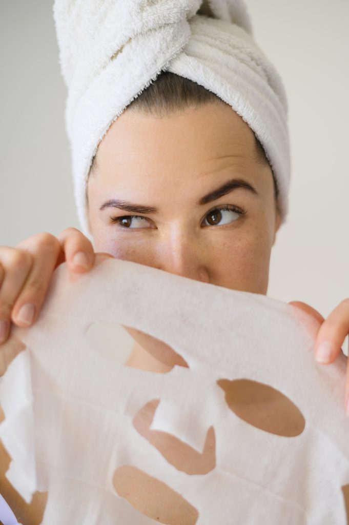 front-view-woman-holding-face-mask